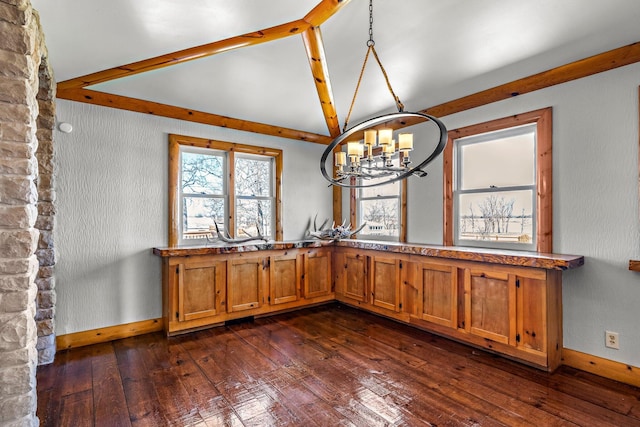 unfurnished dining area with an inviting chandelier, vaulted ceiling with beams, dark wood-style floors, and baseboards