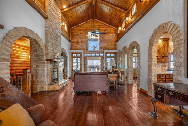 living area with hardwood / wood-style floors, high vaulted ceiling, arched walkways, wooden ceiling, and beamed ceiling