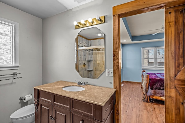 full bath featuring baseboards, ceiling fan, toilet, wood finished floors, and vanity