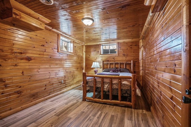 dining space with wooden ceiling, wooden walls, and wood finished floors