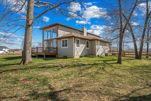 rear view of property featuring fence, a wooden deck, a yard, a chimney, and central air condition unit