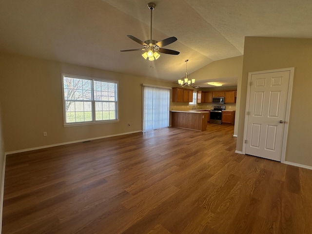 unfurnished living room with ceiling fan with notable chandelier, dark wood-type flooring, baseboards, and vaulted ceiling