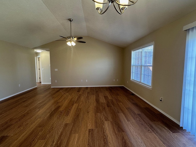 unfurnished room featuring baseboards, lofted ceiling, dark wood-style flooring, a textured ceiling, and ceiling fan with notable chandelier