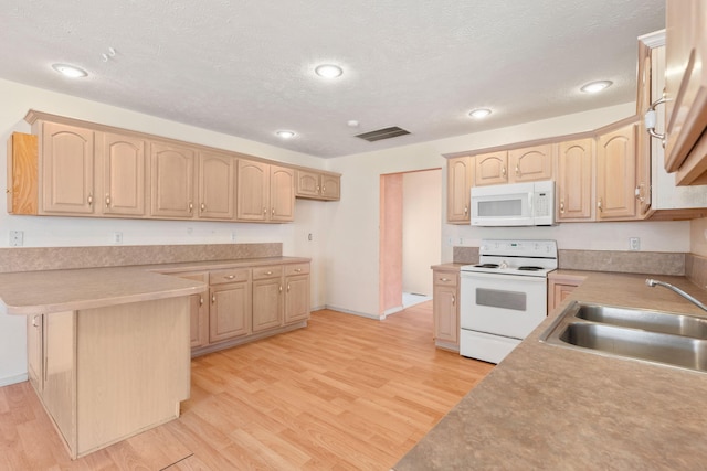 kitchen featuring light wood finished floors, visible vents, light brown cabinetry, white appliances, and a sink