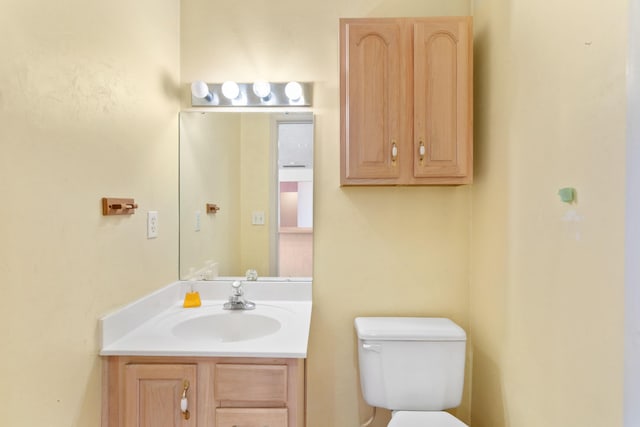 half bathroom with vanity and toilet