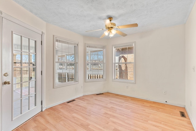 unfurnished sunroom featuring visible vents and ceiling fan