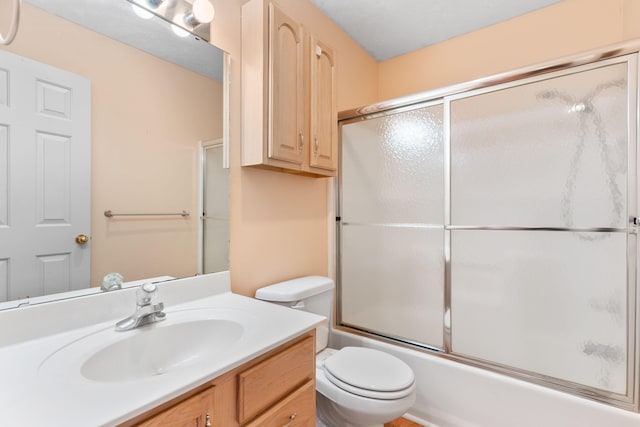 bathroom featuring enclosed tub / shower combo, toilet, and vanity