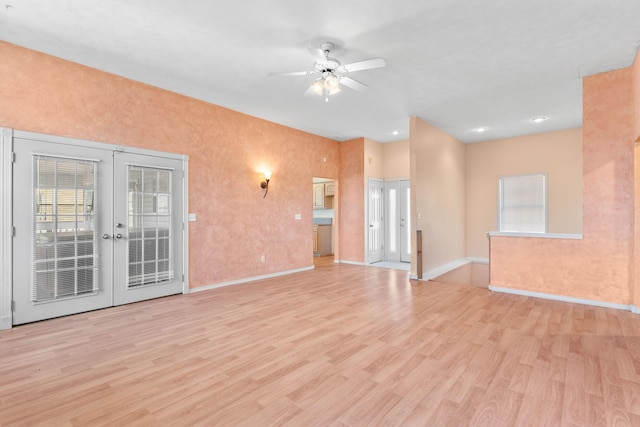 unfurnished living room with french doors, light wood-style floors, a healthy amount of sunlight, and ceiling fan