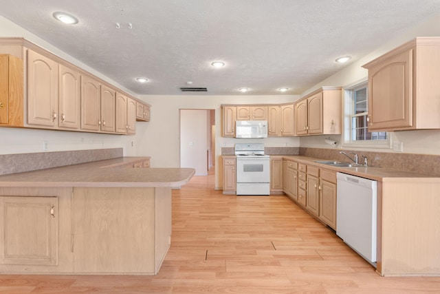 kitchen with light wood-type flooring, visible vents, white appliances, and light brown cabinets