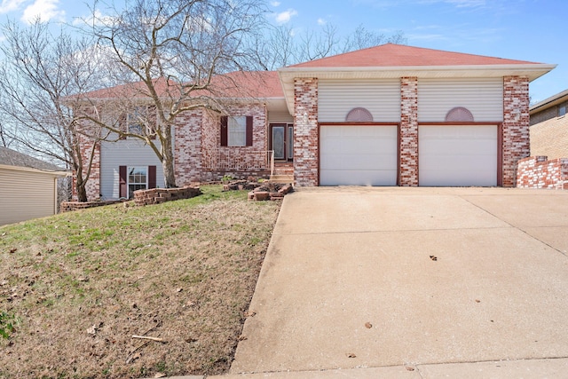 view of front facade with a front lawn, an attached garage, brick siding, and driveway