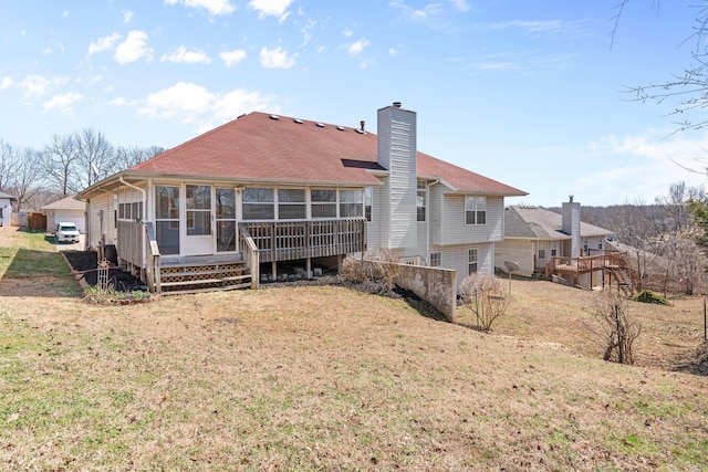 rear view of house with a lawn, a chimney, and a sunroom