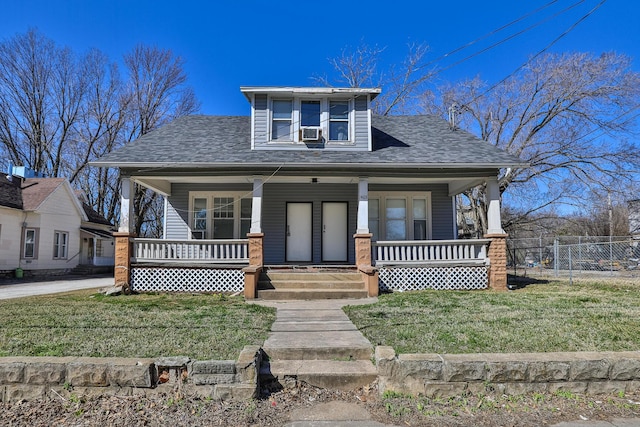 bungalow-style home featuring a shingled roof, fence, a front yard, covered porch, and cooling unit