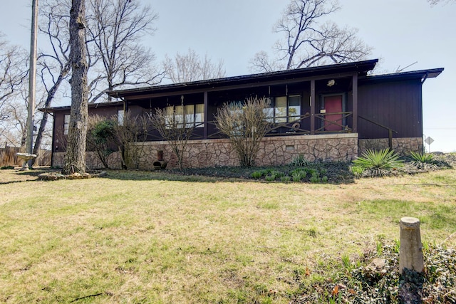 view of front of property with stone siding and a front lawn