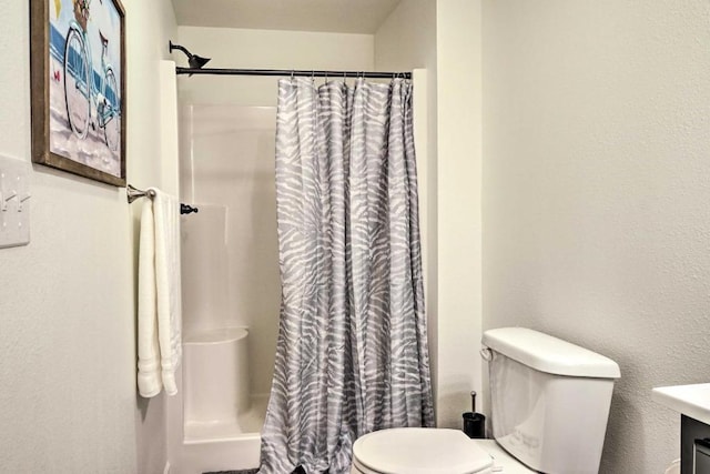 full bathroom featuring a shower with shower curtain and toilet