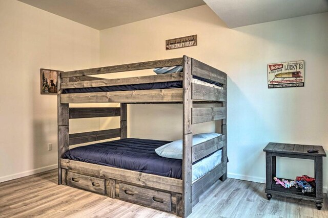 bedroom featuring wood finished floors and baseboards