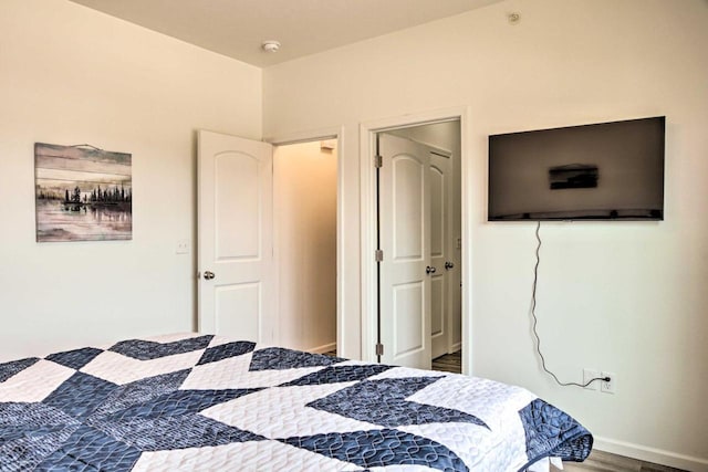 bedroom with baseboards and wood finished floors