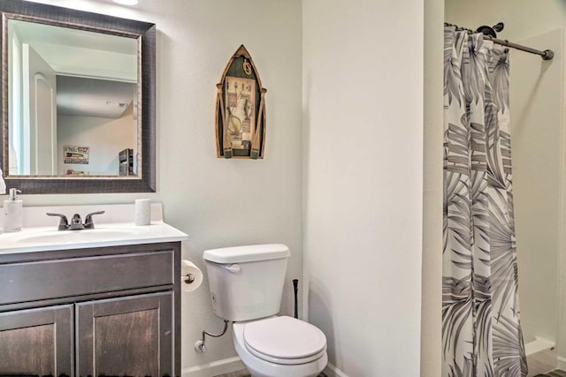 full bathroom featuring a shower with shower curtain, toilet, vanity, and baseboards