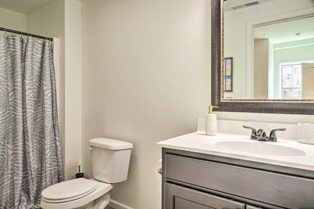 full bathroom featuring visible vents, toilet, curtained shower, baseboards, and vanity