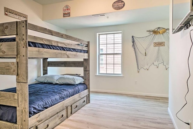 bedroom featuring visible vents, baseboards, and wood finished floors