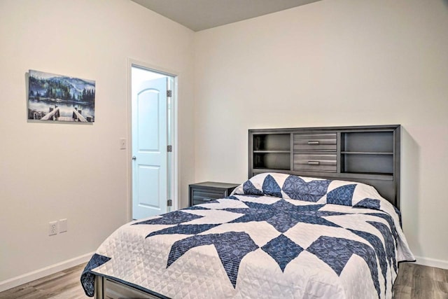 bedroom featuring wood finished floors and baseboards