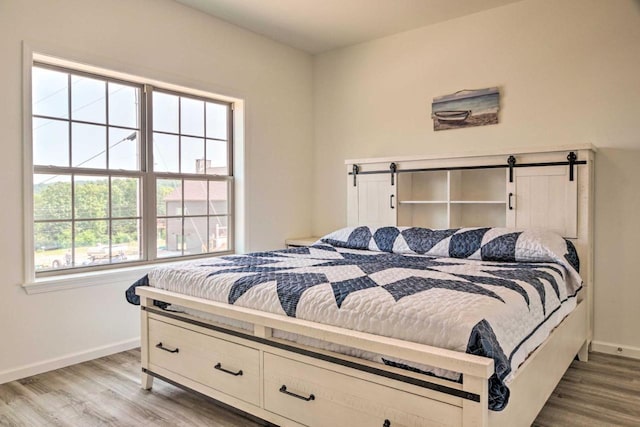 bedroom featuring baseboards and wood finished floors