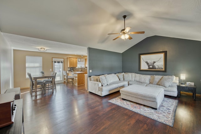 living area featuring ceiling fan, dark wood-style flooring, and vaulted ceiling