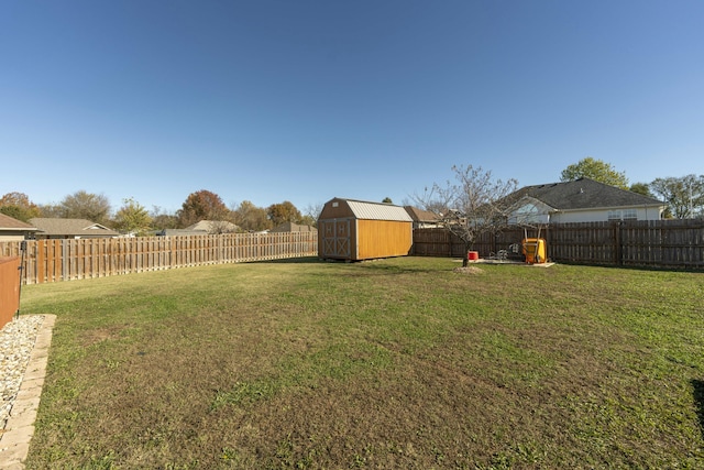 view of yard featuring an outbuilding, a fenced backyard, and a shed