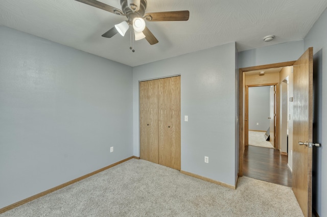 unfurnished bedroom featuring a closet, ceiling fan, carpet, and baseboards