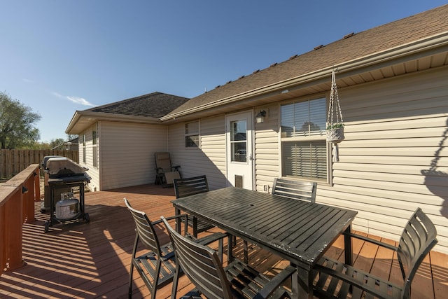 wooden terrace with outdoor dining area and fence