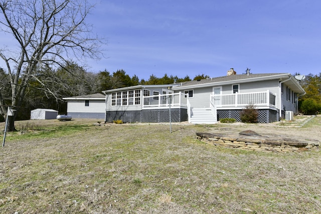 rear view of house featuring a chimney and a wooden deck