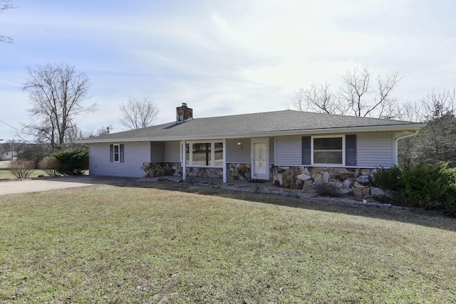 single story home featuring a front yard, roof with shingles, covered porch, a chimney, and stone siding