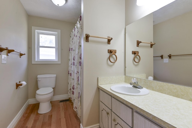 full bathroom featuring visible vents, baseboards, toilet, wood finished floors, and vanity