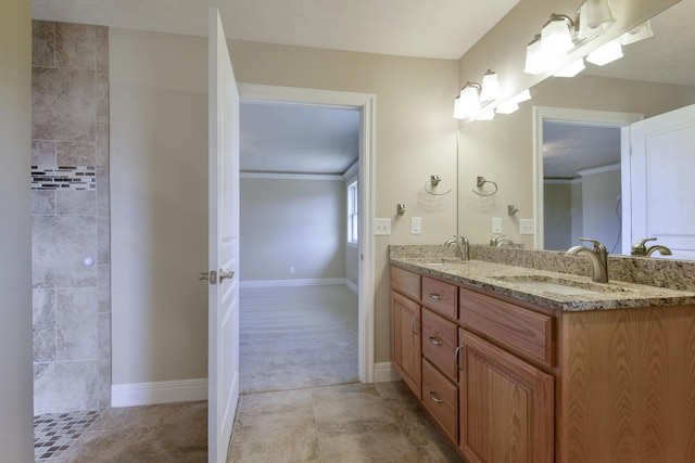 bathroom with double vanity, baseboards, and a sink