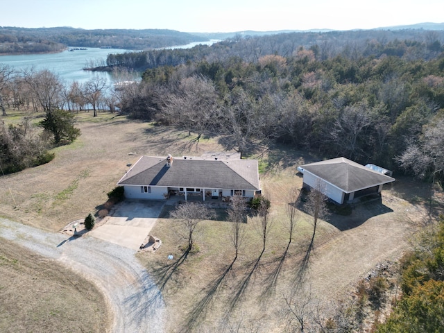 drone / aerial view featuring a wooded view and a water view