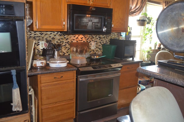 kitchen featuring dark countertops, brown cabinets, backsplash, and black appliances