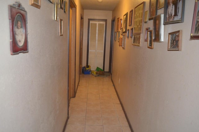 hallway with light tile patterned floors and baseboards