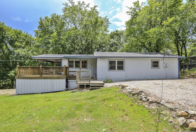 manufactured / mobile home featuring a front lawn and a wooden deck