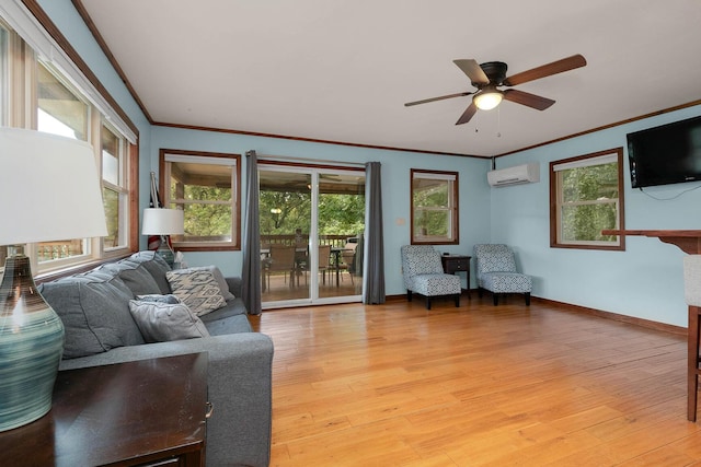 living area with a wall unit AC, crown molding, baseboards, and light wood-type flooring