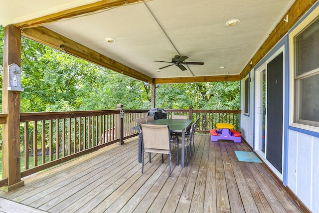 wooden deck with outdoor dining space and ceiling fan