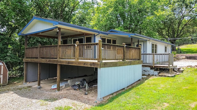 back of property with a lawn, driveway, and a wooden deck