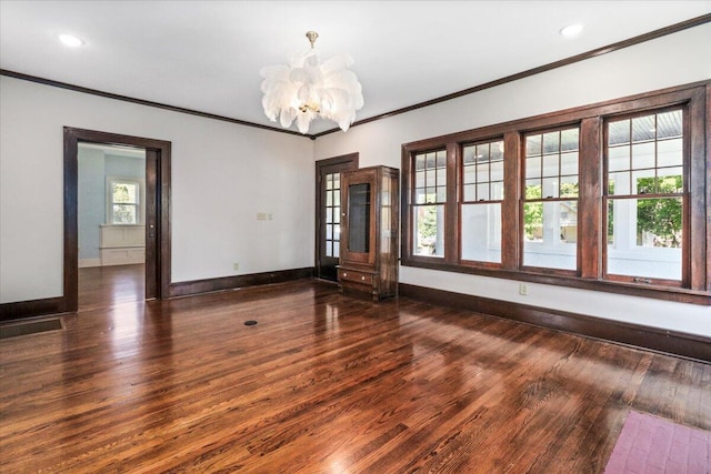 unfurnished room featuring plenty of natural light, wood finished floors, baseboards, and ornamental molding