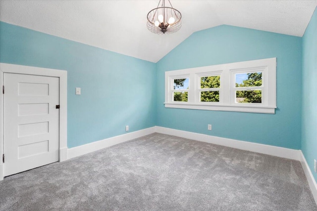 unfurnished room with a chandelier, carpet floors, baseboards, and vaulted ceiling