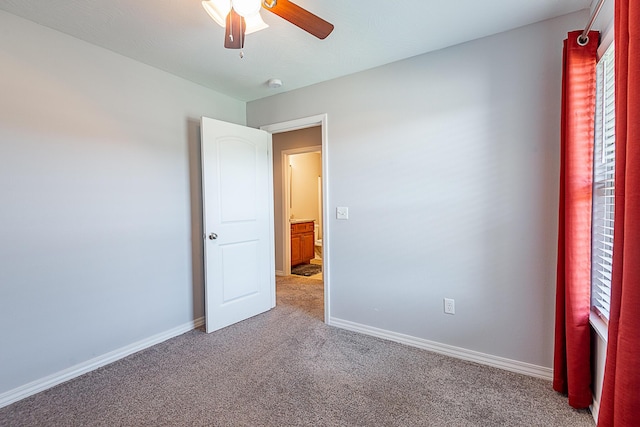 carpeted spare room with baseboards and ceiling fan