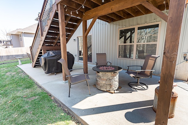 view of patio featuring a fire pit, area for grilling, stairs, and fence