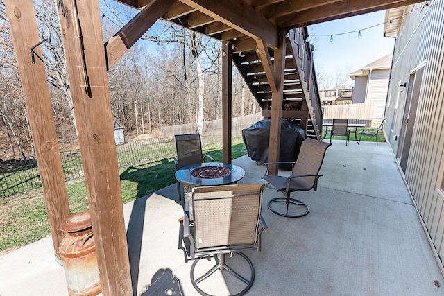 view of patio featuring a fire pit, area for grilling, a fenced backyard, and stairs