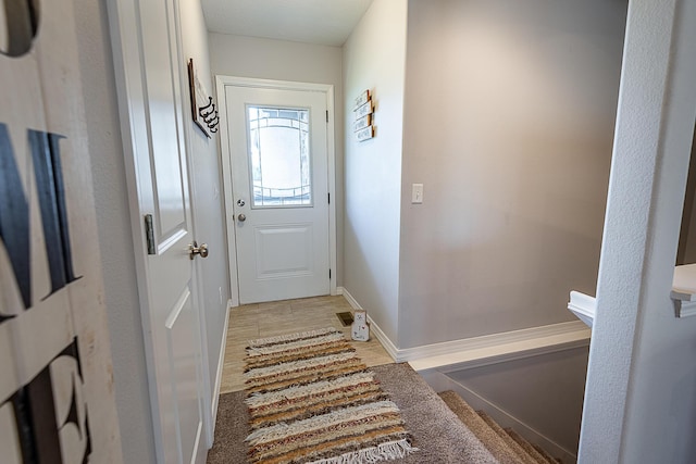 doorway to outside with baseboards and light wood finished floors