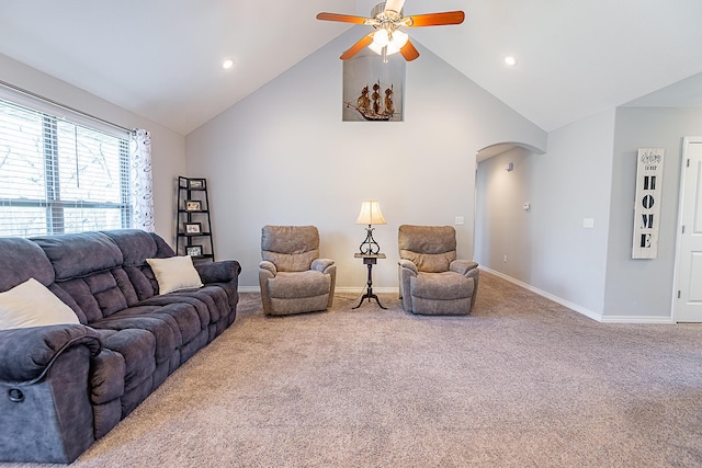 carpeted living area with baseboards, arched walkways, high vaulted ceiling, and a ceiling fan