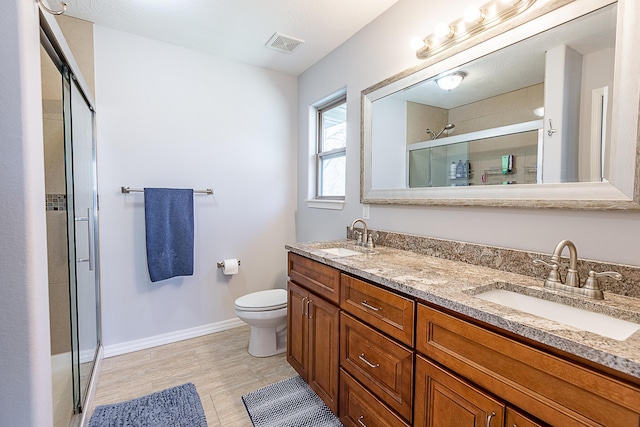 bathroom with double vanity, visible vents, a stall shower, and a sink