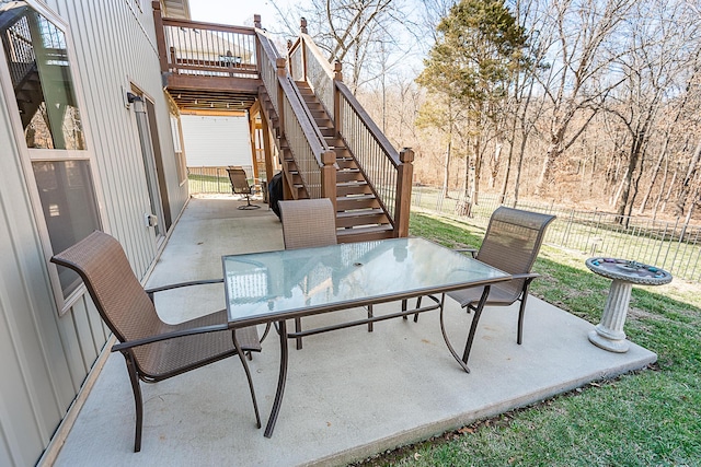 view of patio featuring stairway, outdoor dining area, and fence