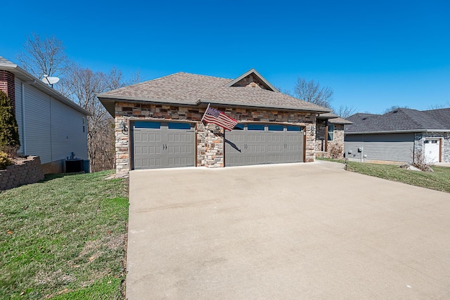 view of front of home with a garage, stone siding, central air condition unit, and a front lawn